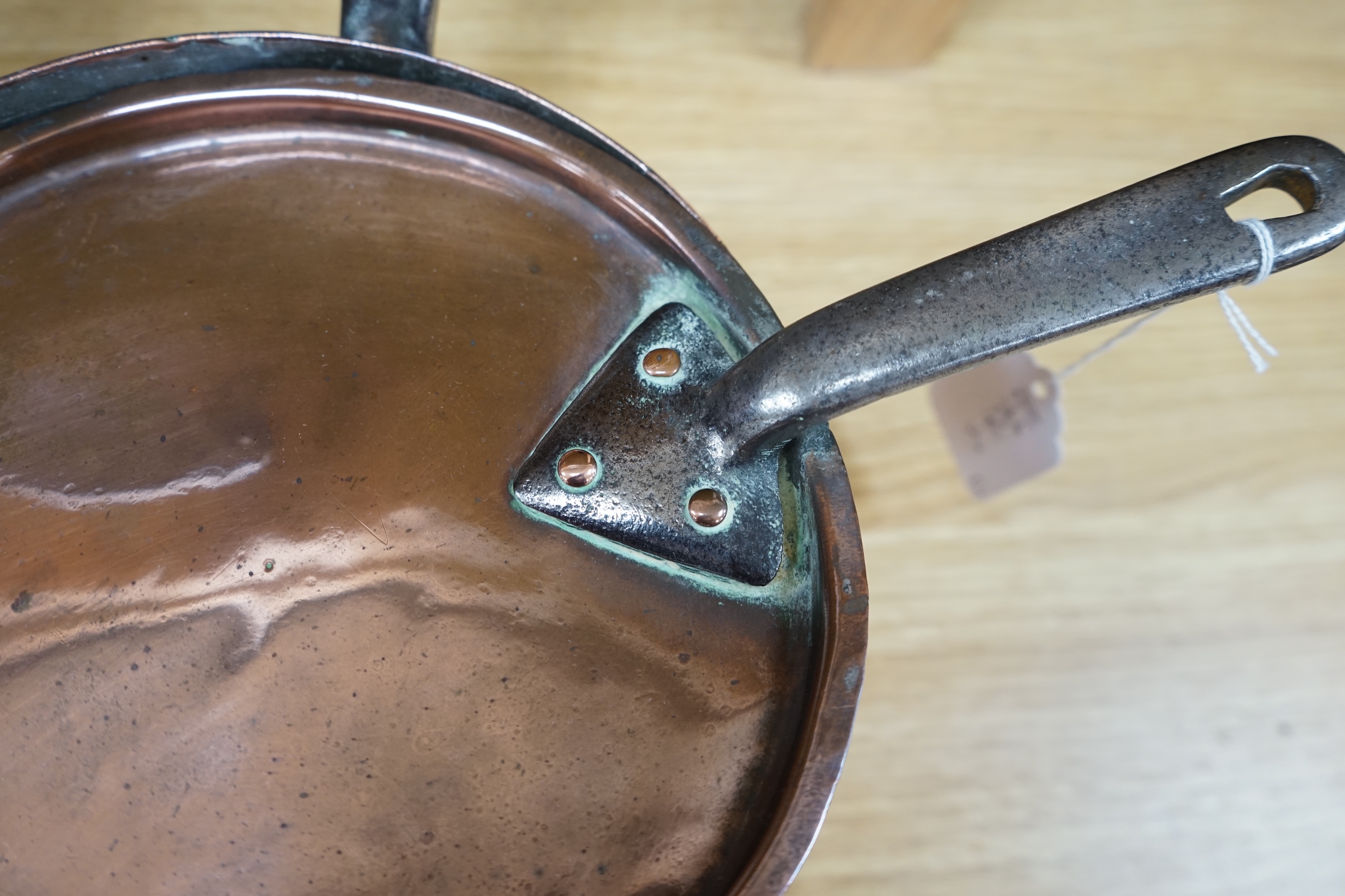 Two 19th century graduated copper and wrought iron saucepans and covers. Condition - fair to good